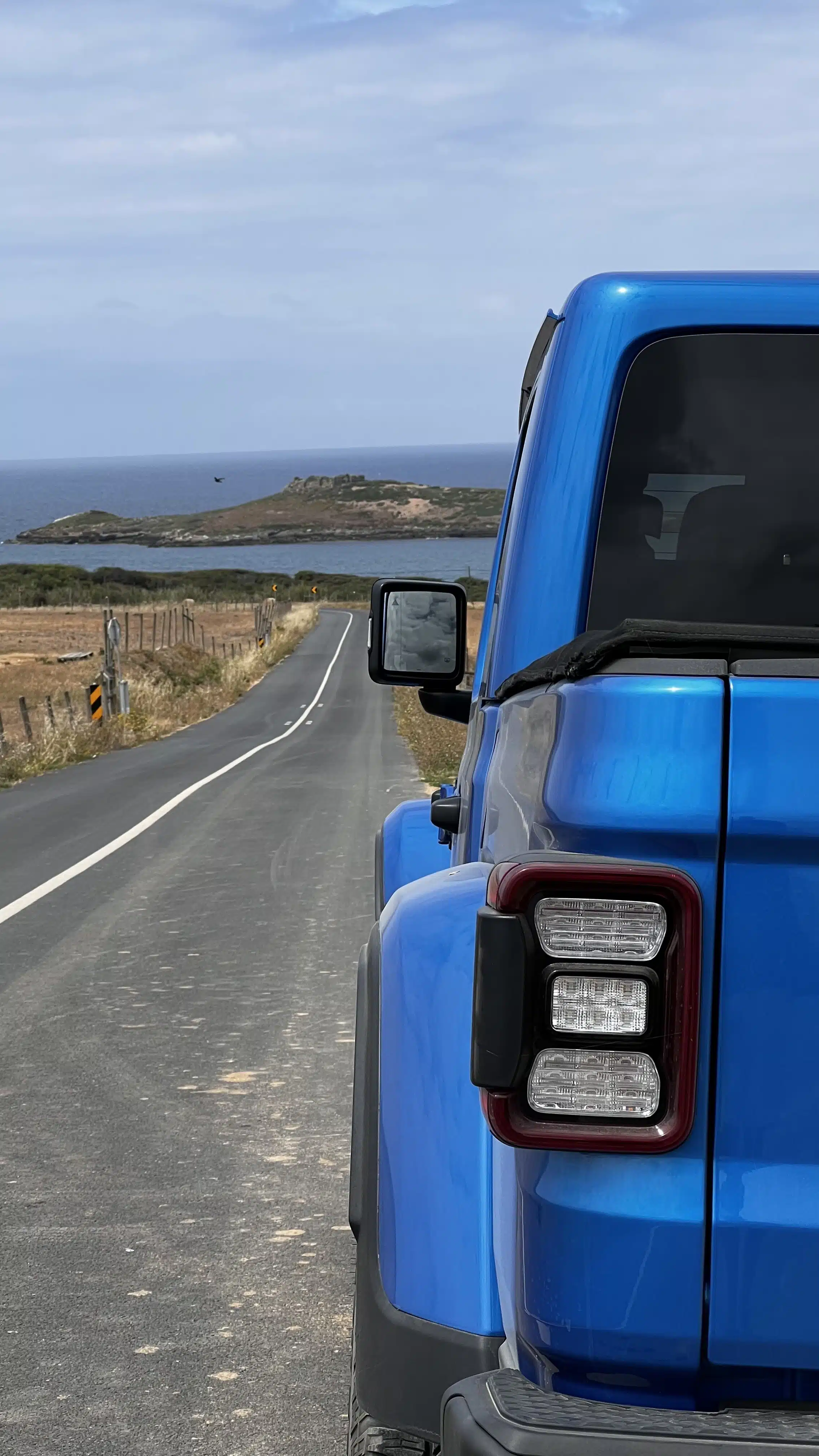 JEEP Gladiator detalhe traseira com vista para estrada e mar ao fundo