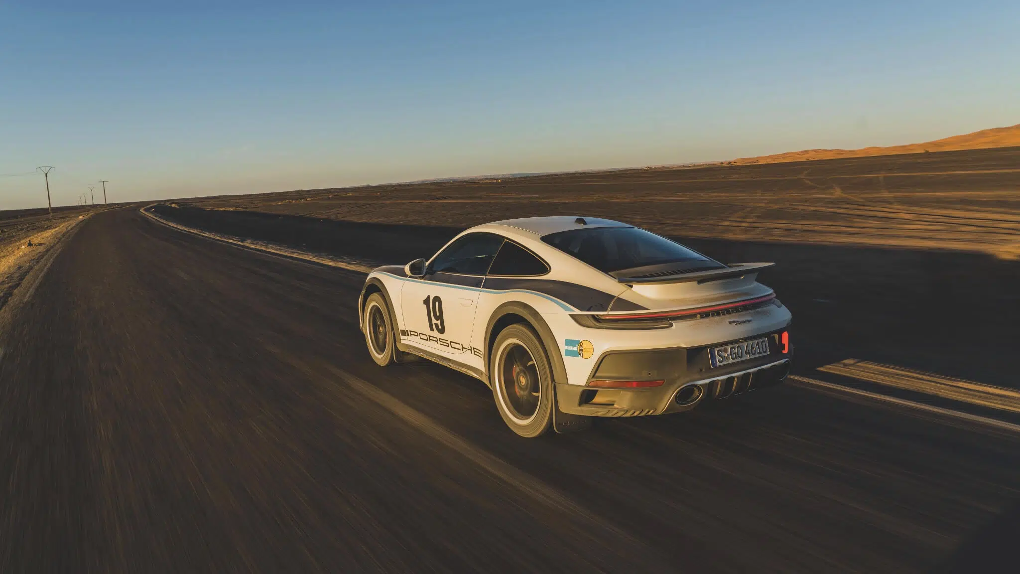 Porsche 911 Dakar Rally 1974, em movimento em estrada no deserto, traseira