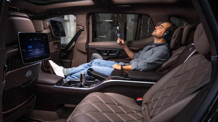 Guilherme sentado na poltrona traseira do Mercedes-Maybach EQS SUV