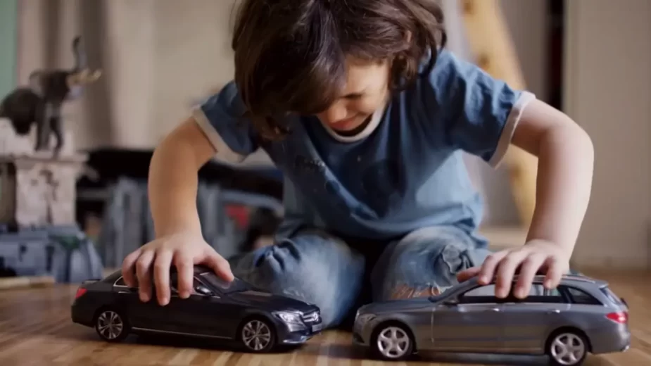Criança a brincar com modelos da Mercedes